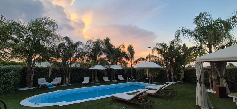 Cielo rosa al tramonto sopra la piscina